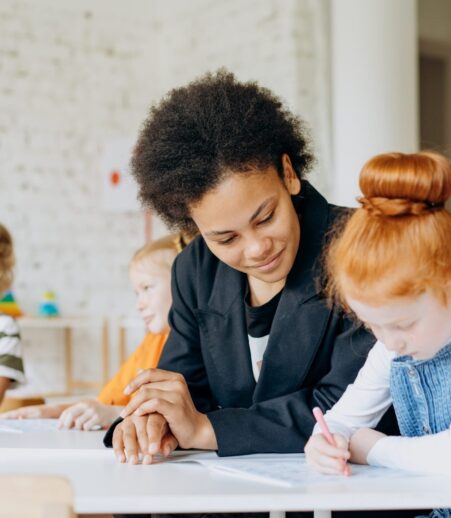 Teacher working with student at desk