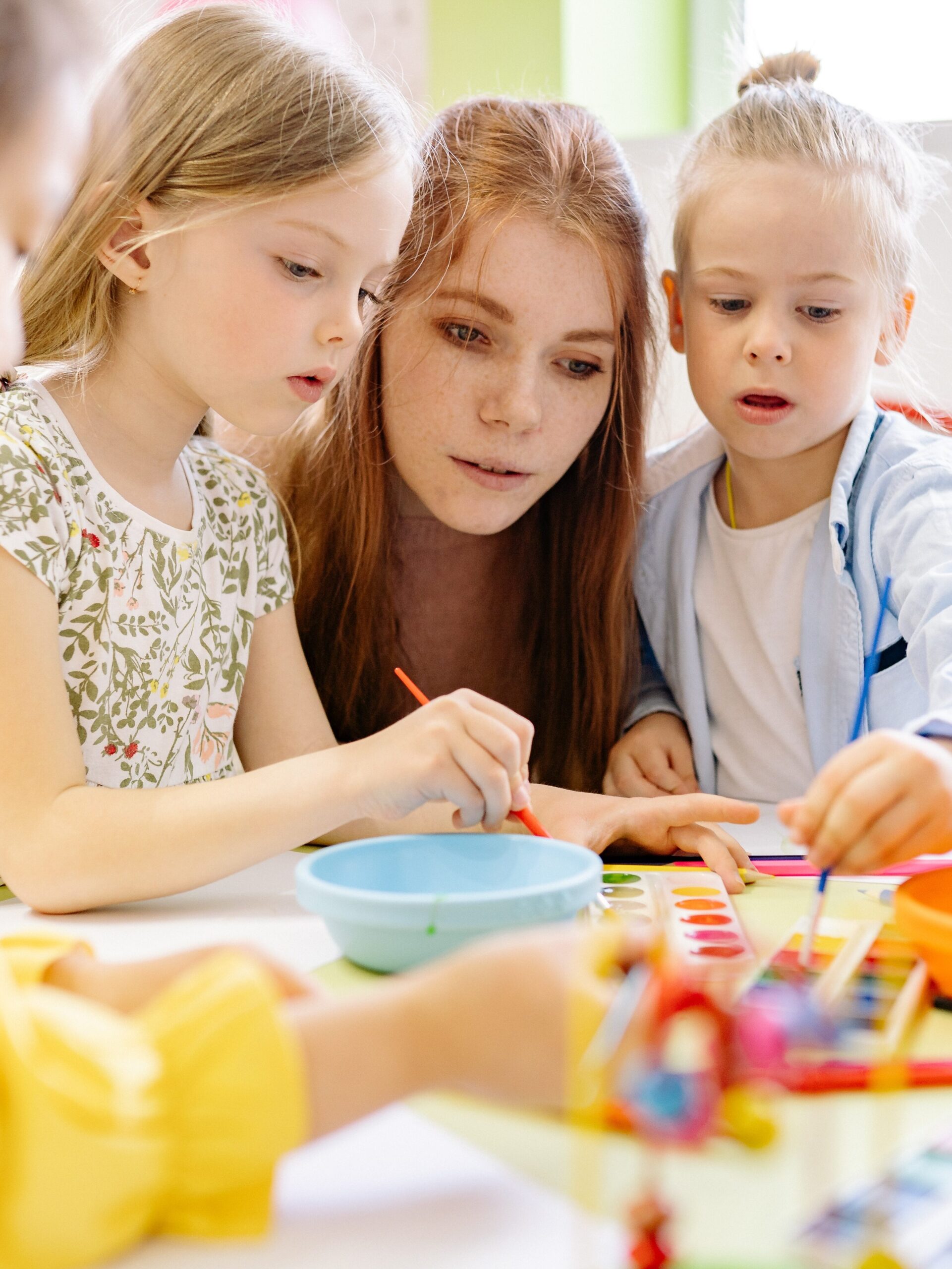 Students gathering around teacher in classroom