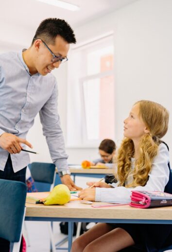 Teacher interacting with student at desk