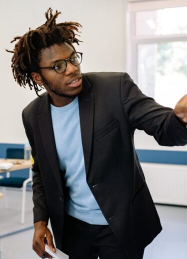 Teacher in black suit teaching a class
